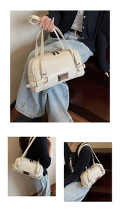 Chic cream white Boston bag with glossy finish and silver buckle on dark wooden stairs