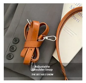 Détail de la bandoulière réglable en cuir marron avec boucle en métal argenté