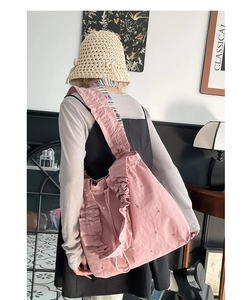Detail der rosa Plissee-Einkaufstasche mit Rüschen, Perlen und gestreiftem Schultergurt