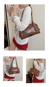 Detail view of brown faux leather Boston bag with metallic buckle and silver logo plate