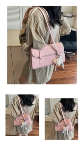 Pink textured leather shoulder bag featuring heart pearl and ribbon bow charm detail