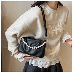 Détail du sac froissé noir avec chaîne de perles élégante et bandoulière en cuir