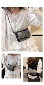 Detail of gray washed denim crossbody bag with metallic chain strap and flap closure
