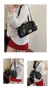 Detail of black glossy Boston bag showing silver hardware and side zipper accents