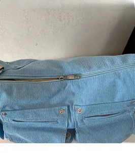 Détail de la fermeture éclair et des rivets sur le sac fourre-tout en velours bleu ciel