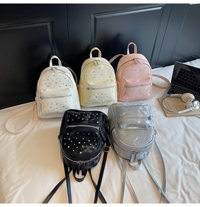Macro shot of stylish quilted mini backpacks in five colors with sequin decorations