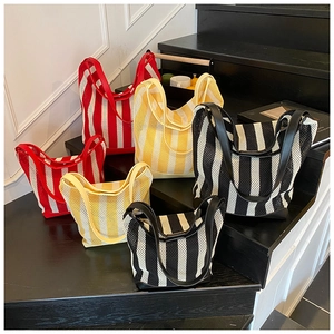 Detailed comparison of striped mesh bucket bags in red, yellow, and black colors