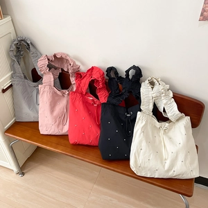 Detail of five colorful nylon tote bags with rhinestone accents and ruffled straps