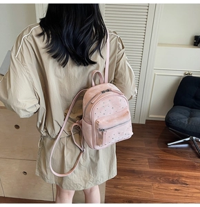 Close-up of pink mini rhinestone backpack being worn to show small size and suede texture