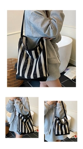 Detail of a black and white vertical striped mesh hobo bag with reinforced black strap