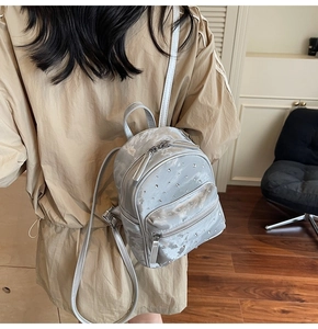 Détail de la vue arrière d'un petit sac à dos argenté avec strass et fines bretelles