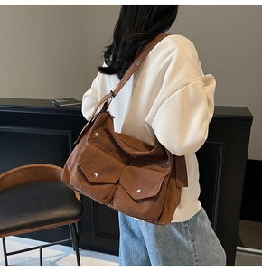 Détail de la besace en velours côtelé marron foncé avec double poche et sangle réglable