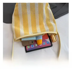 Overhead macro view of striped knit bucket bag showing spacious interior with tablet and phone