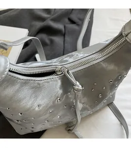 Detailed macro view of the silver rhinestone bag's metallic zipper and leather puller