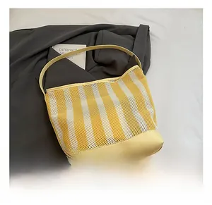 Detail showing yellow and white striped mesh bucket bag with reinforced leather bottom