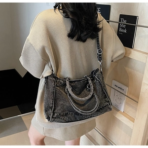 Détail d'un sac cabas en jean gris foncé délavé avec bandoulière réglable et ferrures argentées