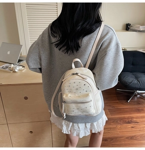 Detail view of mini quilted backpack with silver rhinestone studs and top handle