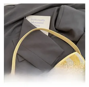 Detail of yellow and beige striped knit shoulder bag with smooth durable handle