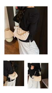 Détail du sac crème avec rivets métalliques, chaîne de perles et nœud en dentelle
