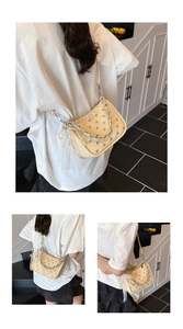 Détail du sac à bandoulière punk beige avec rivets argentés et pendentif en perles