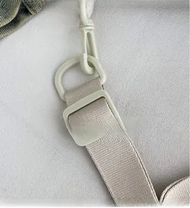 Detail shot of the adjustable beige nylon shoulder strap with matte plastic buckle