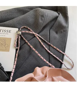 Detail of pink ruched shoulder bag with silver chain strap and leather texture