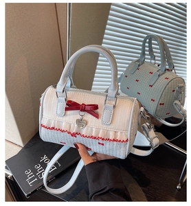 Detail of Boston bag with red bow embroidery and heart-shaped metal logo charm