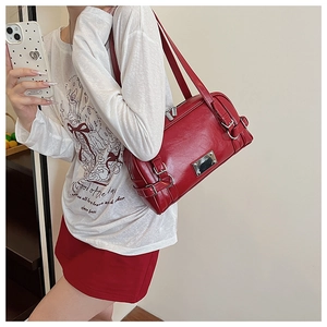 Side view of dark red Boston shoulder bag with silver hardware on female model