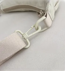 Detail of detachable matte plastic swivel hook and matching woven shoulder strap on a nylon bag