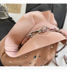 Detail of pink pleated bag with shimmering fabric, crystal studs, and silver hardware