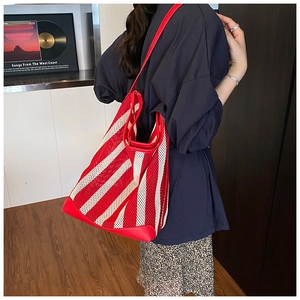 Détail du sac fourre-tout rayé rouge et blanc avec garniture et lanières en cuir chic