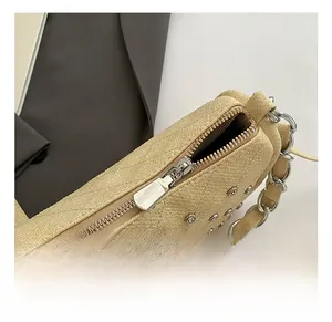 Détail de la fermeture éclair en métal argenté et texture tissée du sac à chaîne