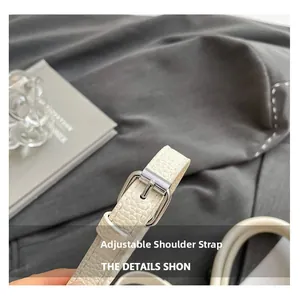 Vue détaillée de la bandoulière réglable en cuir blanc avec boucle métallique argentée