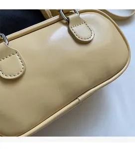 Detail of light yellow Boston handbag showing silver metal hardware and smooth leather texture