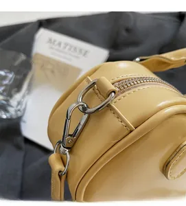 Detail of silver metal hook and zipper closure on a light yellow Boston handbag