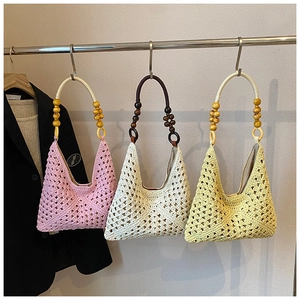 Detail of bohemian woven tote bags with decorative wooden bead handles in various colors