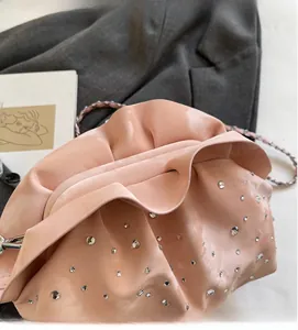 Close-up of pink pleated cloud bag featuring sparkling rhinestones and a metal chain strap
