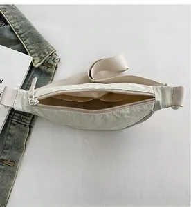 Detailed interior of a beige nylon crossbody bag featuring double slip pockets for storage