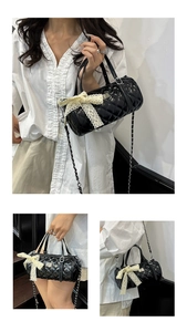 Détails du sac cylindrique matelassé noir avec un grand nœud en dentelle et une chaîne