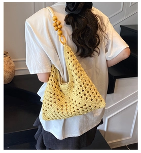 Detail of yellow knit crochet tote bag showing triangle weave and wooden beads