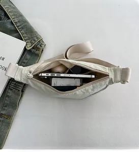 Internal view of beige nylon crossbody bag showing space for phone and makeup