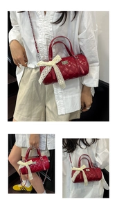 Détail du sac cylindrique rouge matelassé avec nœud en dentelle et bandoulière