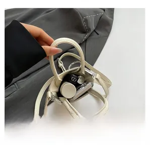 Vue de dessus de l'intérieur du sac seau crème avec téléphone et rouge à lèvres