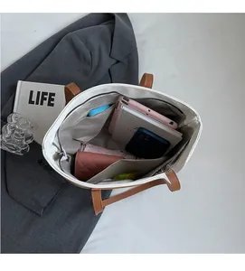 Interior view of large capacity tote bag with organized compartments for tablet and umbrella