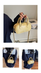 Close-up of yellow mini Boston bag with glossy PU leather and adjustable shoulder strap