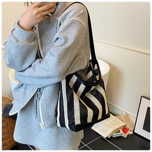 Vue détaillée du grand sac cabas en maille à rayures noires et blanches à l'épaule