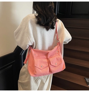 Sac fourre-tout rose en velours côtelé avec double poche avant porté par un mannequin