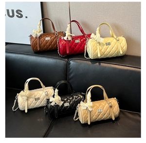 Détail de sacs polochons matelassés en six couleurs avec nœuds en dentelle et chaînes