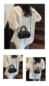 Detailed view of black Boston mini bag with glossy finish and silver metal zippers