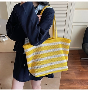 Detail showing the yellow and white striped woven texture and thin faux leather handles